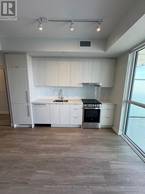 A modern kitchen with white cabinets and a stainless steel stove.