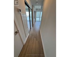 A hallway with wood flooring and white walls.