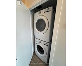 A stack of two white washing machines in a small laundry room.