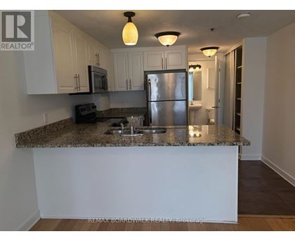 A kitchen with granite countertops and stainless steel appliances.