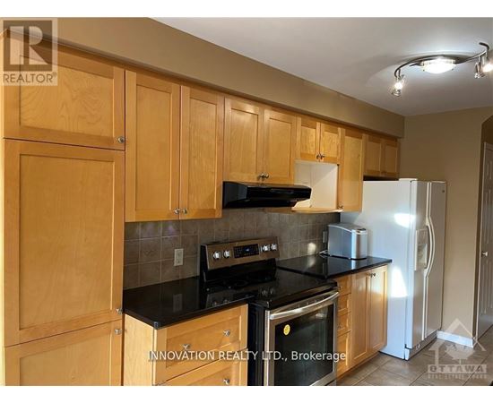 A kitchen with wooden cabinets and black countertops.