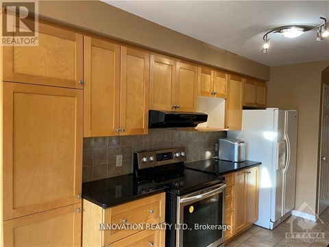 A kitchen with wooden cabinets and black countertops.