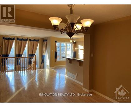 A well-lit, spacious room with a chandelier and hardwood floors.