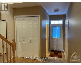 A hallway with a white door and a window with a blue sky in the background.
