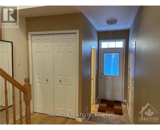 A hallway with a white door and a window with a blue sky in the background.