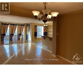 A well-lit, spacious room with a chandelier and hardwood floors.
