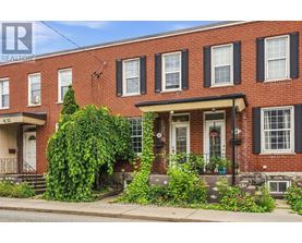 A red brick house with a white door and windows.