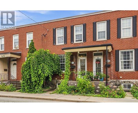 A red brick house with a white door and windows.
