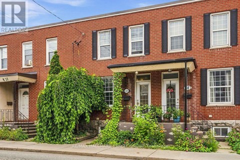 A red brick house with a white door and windows.