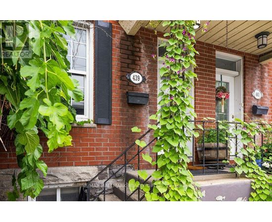 A red brick house with a white door and a mailbox with the number 439 on it.