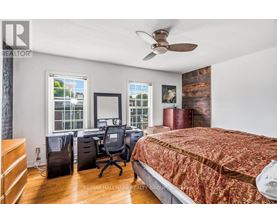 A bedroom with a bed, desk, and chair.