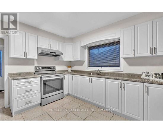 A kitchen with white cabinets and a stainless steel oven.
