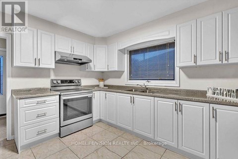 A kitchen with white cabinets and a stainless steel oven.