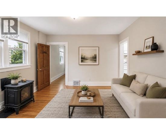 A living room with a white couch, a black fireplace, and a painting on the wall.