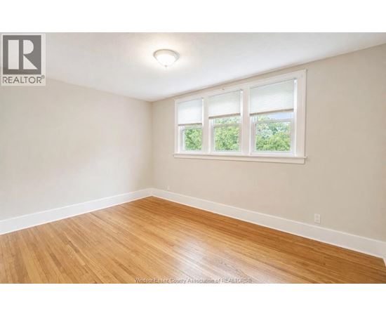 A room with a window and wooden flooring.