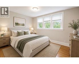 A bedroom with a large bed and a window with a view of greenery outside.