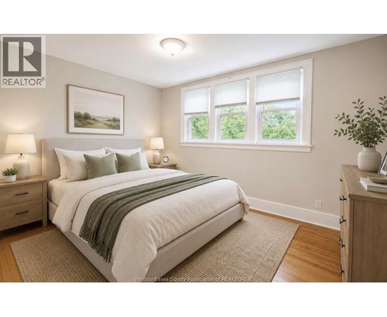 A bedroom with a large bed and a window with a view of greenery outside.