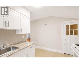 A kitchen with white cabinets and a granite countertop.