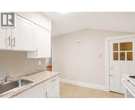 A kitchen with white cabinets and a granite countertop.