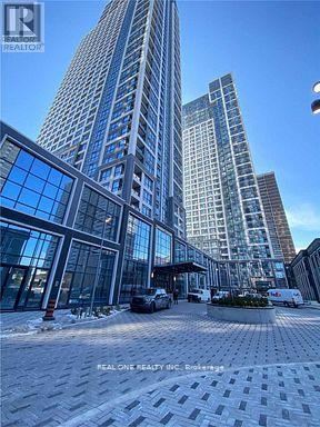 A modern building with a glass facade is surrounded by other buildings.