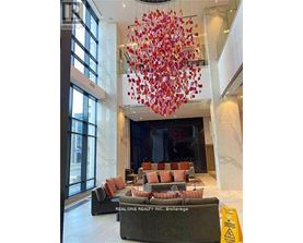 A large chandelier with red and white decorations hangs from the ceiling in a spacious room.