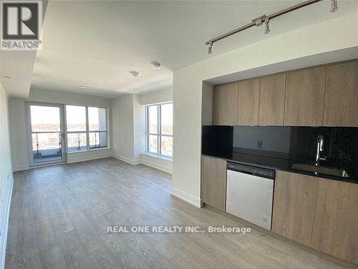 A spacious kitchen with wooden cabinets and a black countertop.