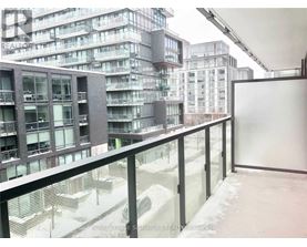 A view of a snowy courtyard from a balcony with buildings in the background.