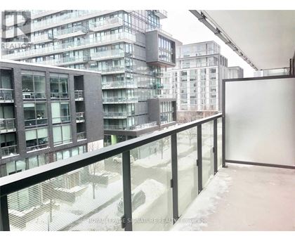 A view of a snowy courtyard from a balcony with buildings in the background.