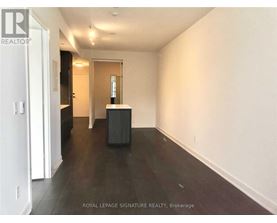 A room with a white wall and a black box on the floor.