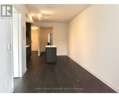 A room with a white wall and a black box on the floor.