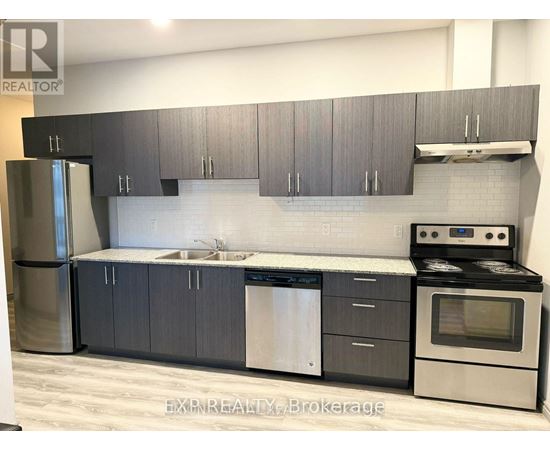 A modern kitchen with dark grey cabinets and stainless steel appliances.