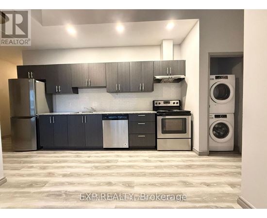 A kitchen with a refrigerator, oven, and washing machine.