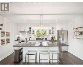 A modern kitchen with white cabinets and a dark countertop.
