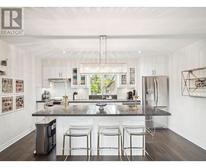 A modern kitchen with white cabinets and a dark countertop.