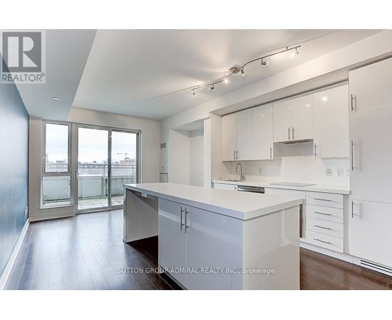 A kitchen with white cabinets and a large island.