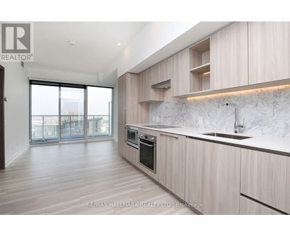 A modern kitchen with wooden cabinets and a marble backsplash.