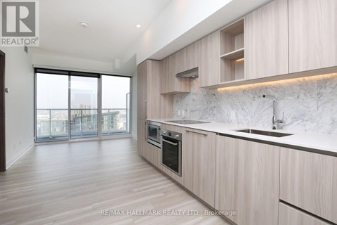 A modern kitchen with wooden cabinets and a marble backsplash.
