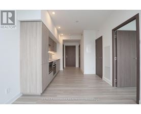 A spacious hallway with wooden floors and white walls.