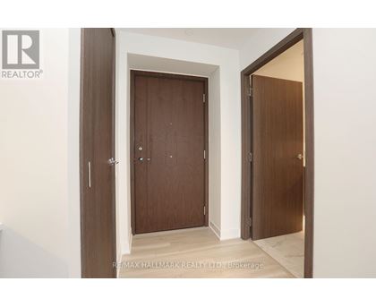 A brokerage sign is on the bottom left of a hallway with two doors.