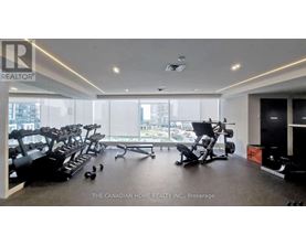 A gym with a row of treadmills and exercise equipment.