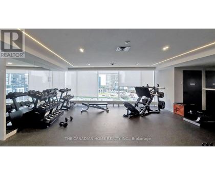 A gym with a row of treadmills and exercise equipment.