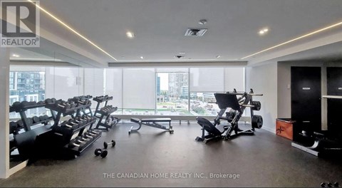 A gym with a row of treadmills and exercise equipment.
