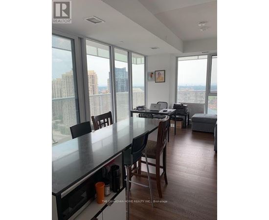 A kitchen with a table and chairs in front of a window overlooking a cityscape.