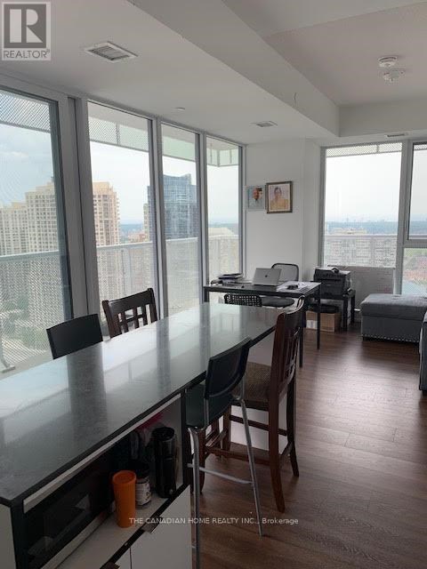 A kitchen with a table and chairs in front of a window overlooking a cityscape.