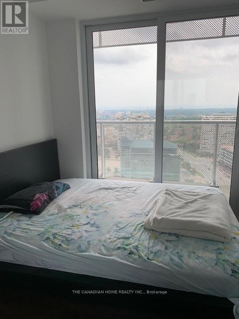 A bedroom with a large window overlooking a cityscape.