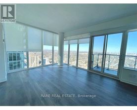 A spacious room with large windows overlooking a cityscape.