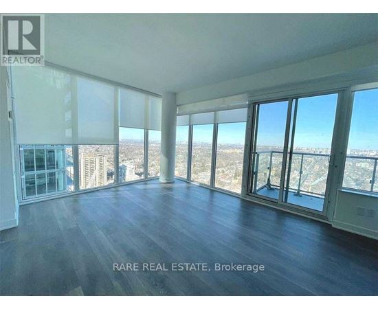 A spacious room with large windows overlooking a cityscape.
