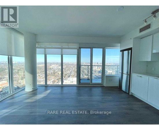 A spacious room with large windows overlooking a cityscape.