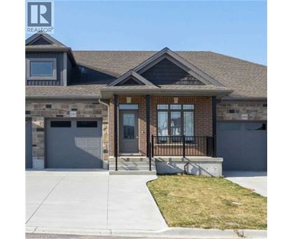 A house with a brown front door and a black railing.