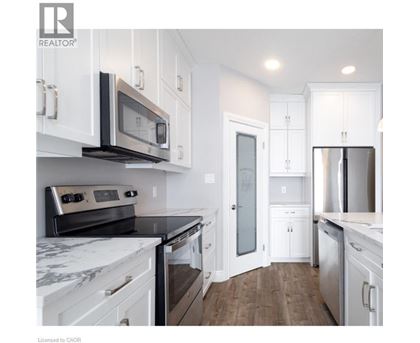 A kitchen with white cabinets and a marble countertop.